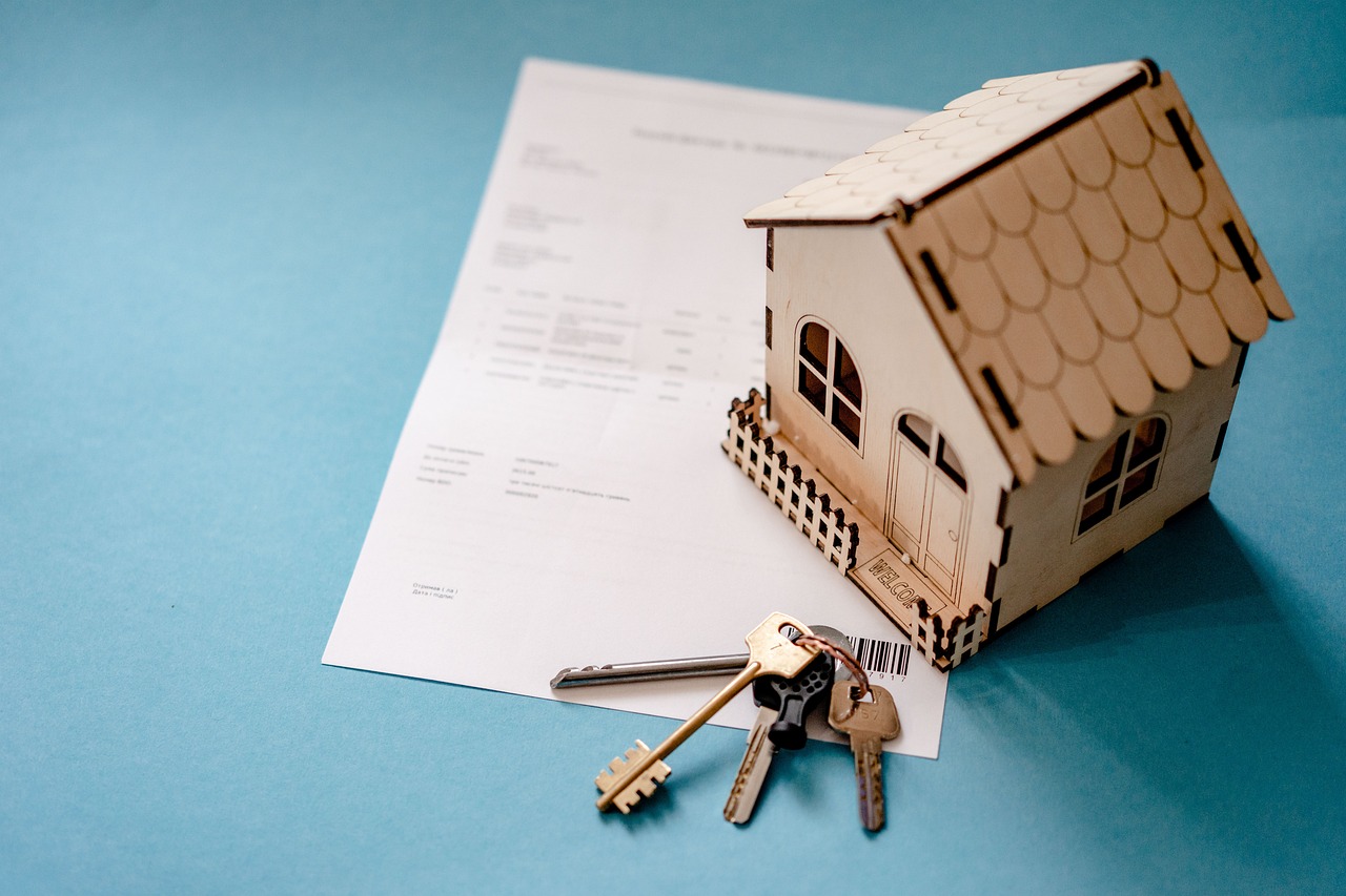 A model house with keys and a deed.